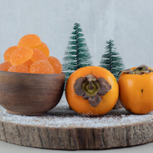 Pair of fresh persimmons with orange marmalades . High quality photo